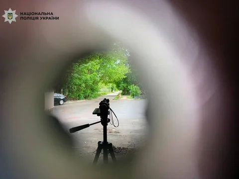 Вид крізь оптичний приціл на вулицю з деревами