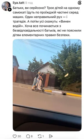 Двоє дітей їдять на самокаті сидячи на дорозі