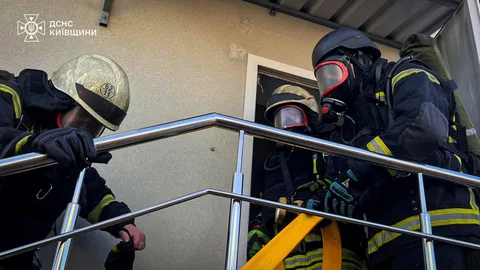 Рятувальники в захисному спорядженні гасять пожежу в будівлі