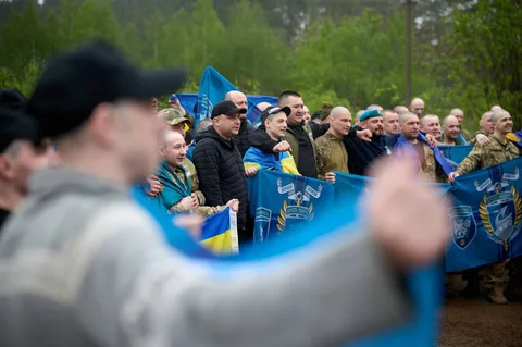 Група людей з українськими прапорами на зустрічі