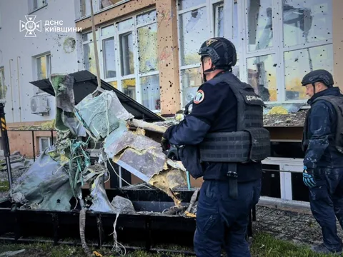 Рятувальники розбирають уламки ракети біля пошкодженої будівлі