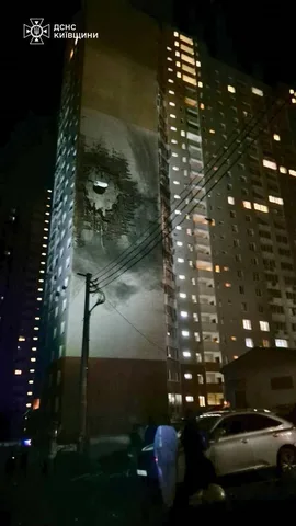 Нічна фотографія багатоповерхового будинку з пошкодженим фасадом