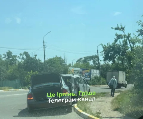 Пошкоджена машина на дорозі біля вантажівок