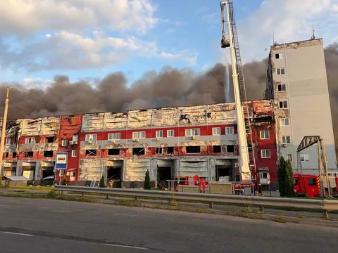 Пошкоджена будівля з димом у повітрі позаду