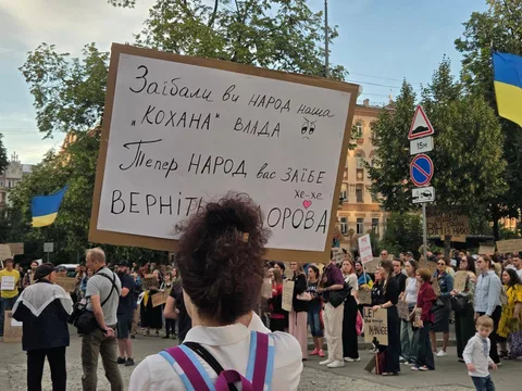 Людина з плакатом на мітингу в центрі міста
