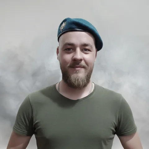Чоловік у синій кепці та оливковій футболці