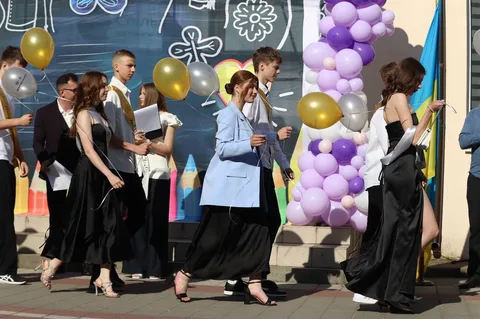 Випускники в чорних мантіях на святкуванні закінчення школи
