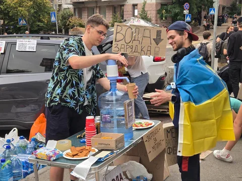Люди роздають воду та їжу на вулиці міста
