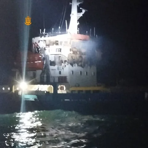 Пошкоджене судно в морі вночі з димом