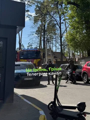 Електричний самокат на тротуарі біля припаркованих автомобілів