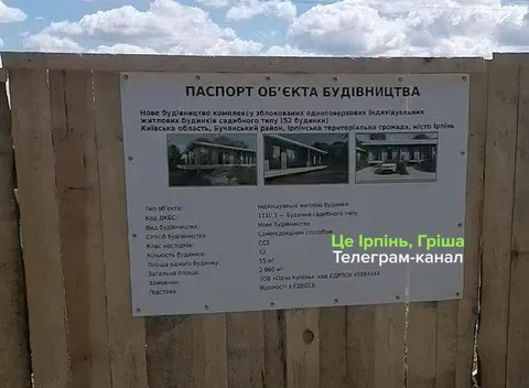 Інформаційна табличка про паспорт об'єкта будівництва на дерев'яному паркані