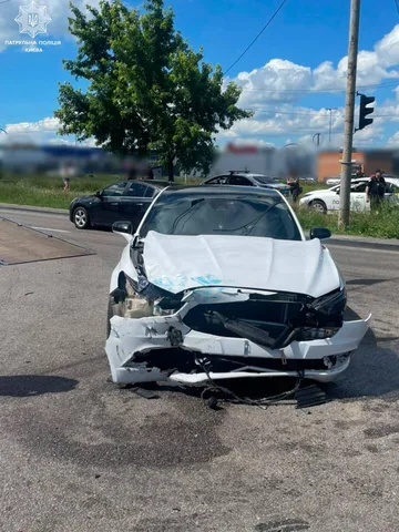 Пошкоджений білий автомобіль після дорожної аварії на перехресті