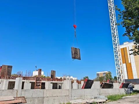 Будівельний кран піднімає матеріали на будівельному майданчику