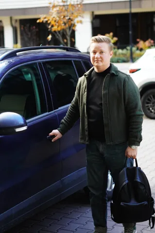 Чоловік зі сумкою біля припаркованого автомобіля