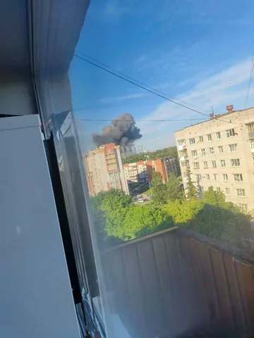 Вид з вікна на будівлю з димом у місті