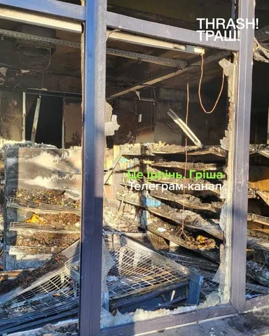Пошкоджена вітрина супермаркету з обломками всередині