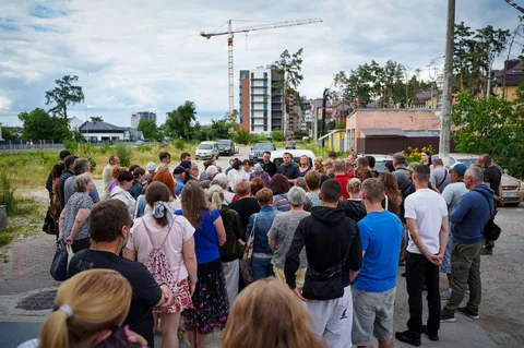 Група людей на вулиці біля будівельного майданчика в Ірпені
