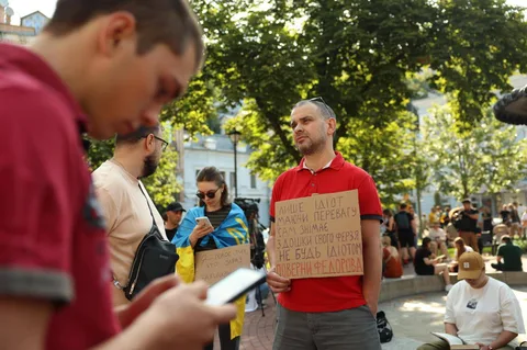 Люди на площі з плакатами під час акції