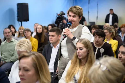 Чоловік зі мікрофоном виступає перед аудиторією людей