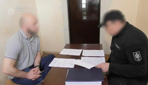 Двоє чоловіків за столом з документами під час розмови