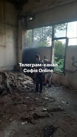 Людина в пошкодженій будівлі з розбитими вікнами