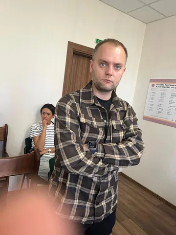 Чоловік у клітчастій сорочці в залі суду