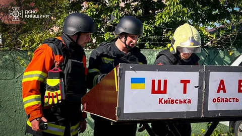 Рятувальники в касках тримають табличку з написом