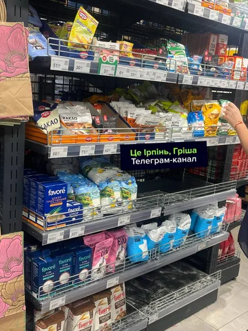 Полиці супермаркету з продуктами та порожніми місцями
