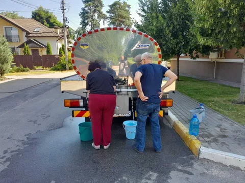 Люди наповнюють контейнери водою з цистерни на вулиці