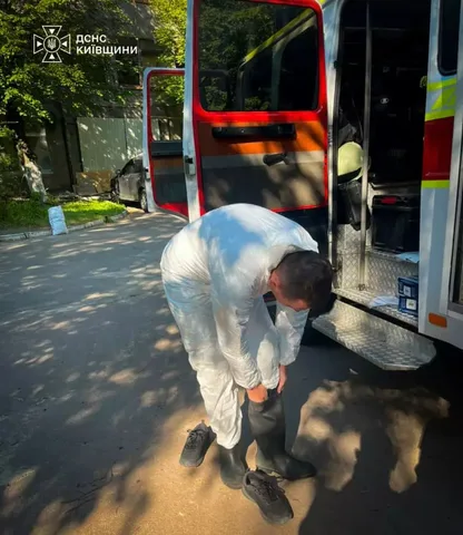 Працівник у захисному костюмі проводить вимірювання на вулиці
