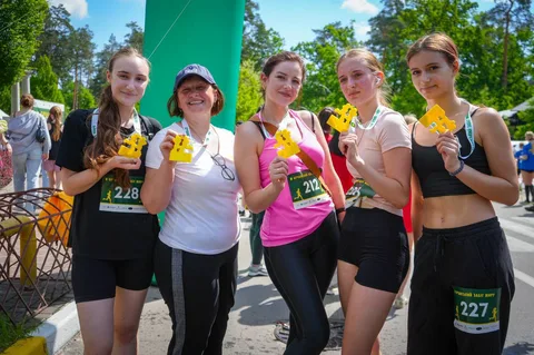П'ять учасниць забігу з медалями на шиї позують для фото