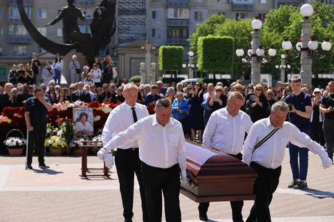 Чоловіки несуть труну на церемонії прощання на площі