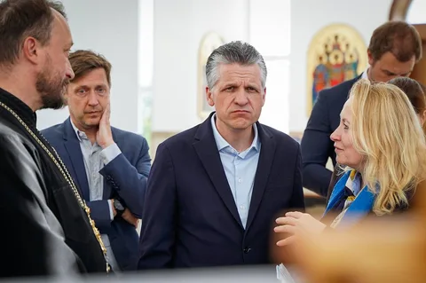 Група людей у діловому одязі спілкується в приміщенні