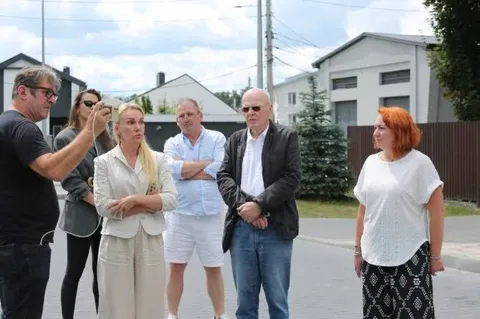 Група людей стоїть на вулиці біля житлових будинків