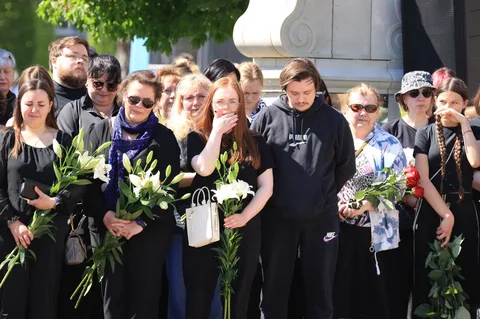 Група людей з квітами на церемонії прощання