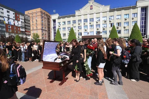 Люди на площі біля відкритої труни під час церемонії прощання
