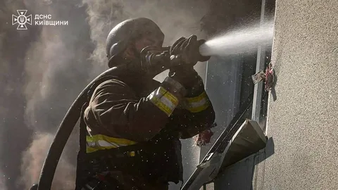 Рятувальник гасить пожежу в будівлі водою