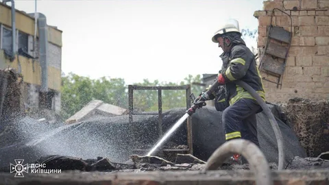 Рятувальник гасить пожежу водою з шланга