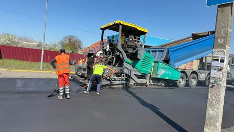Дорожні робітники укладають асфальт спеціальною машиною