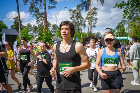 Учасники забігу біжать по вулиці з номерами на грудях