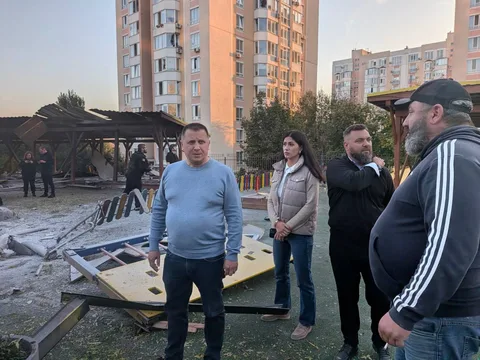 Люди біля пошкодженої будівлі дитсадка в Святопетрівському