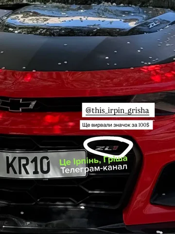 Червоний автомобіль з видимою емблемою на капоті