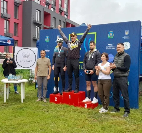 Переможці велогонки на подіумі з медалями та кубками