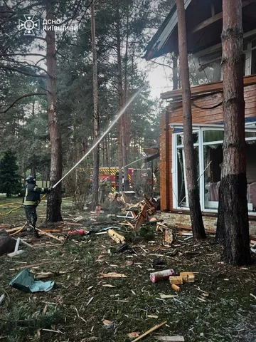 Пошкоджена дача в лісі з обломками дерев