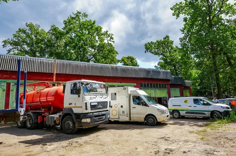 Спеціалізовані автомобілі біля будівлі з червоним дахом