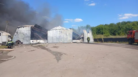 Пожежа на складському приміщенні з дымом та пожежною машиною