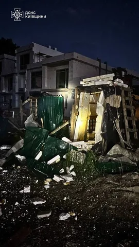 Пошкоджена будівля з обвалом стіни вночі