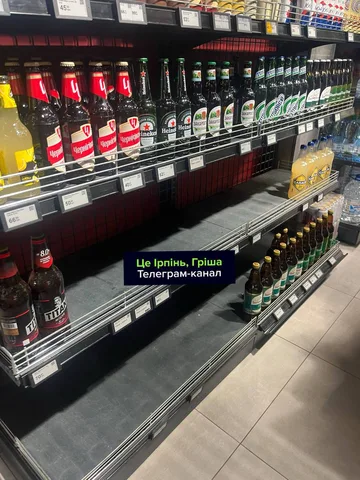 Порожні полиці з напоями в супермаркеті