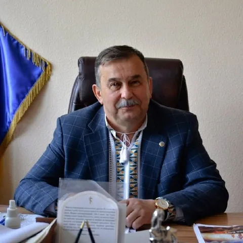 Чоловік у синьому піджаку за офісним столом