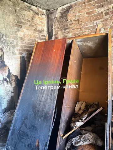 Пошкоджена кімната з обгорілими стінами та залишками речей